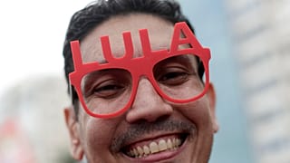 A supporter of Brazilian President Luiz Inacio Lula da Silva wears glasses displaying his name during a campaign rally in Rio de Janeiro, Sunday, Oct. 18, 2026.