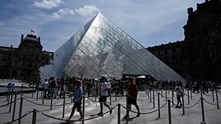 Visitors walks inside the pyramid during the reopening to the public of the Apollo Gallery at the Louvre museum in Paris, 22 July, 2026