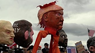 Felvonulók egy transzparenst és Donald Trump amerikai elnök papírmasé figuráját tartják a „No Kings” tüntetésen Washington DC-ben, 2026. október 17-én, szombaton.