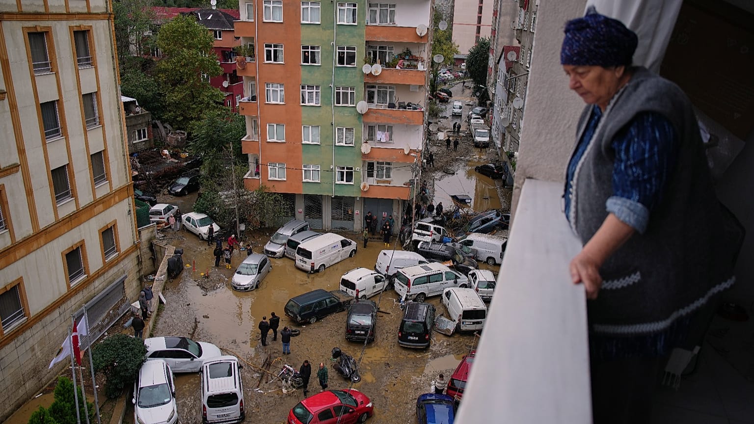 Local residents walk among toppled vehicles and scattered debris in the aftermath of floods caused by heavy rains in Istanbul, 15 October, 2026