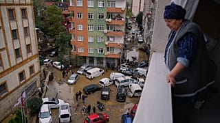 Local residents walk among toppled vehicles and scattered debris in the aftermath of floods caused by heavy rains in Istanbul, 15 October, 2026