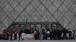 Workers block the entrance of the Louvre museum during a protests against rising living costs, in Paris, Monday, Oct. 19, 2026