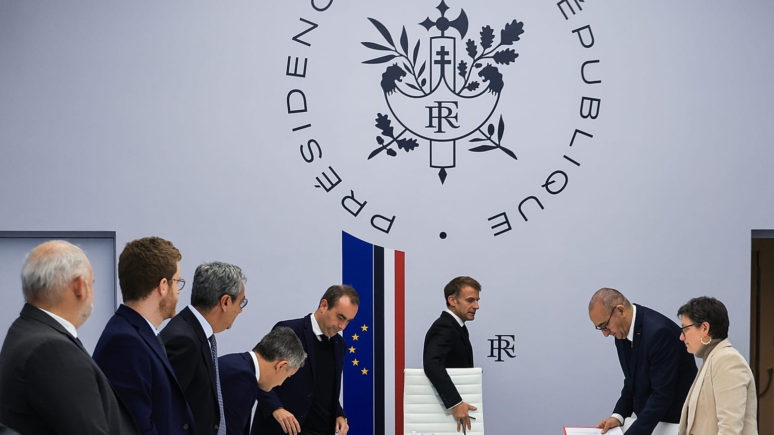 Les ministres français se tiennent debout à l'arrivée du président Emmanuel Macron pour une réunion interministérielle de crise au palais de l'Élysée, le 18 octobre 2026