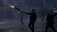 Un manifestante dispara fuegos artificiales contra la policía durante disturbios en una protesta antigubernamental en Tirana, Albania, el domingo 18 de octubre de 2026.