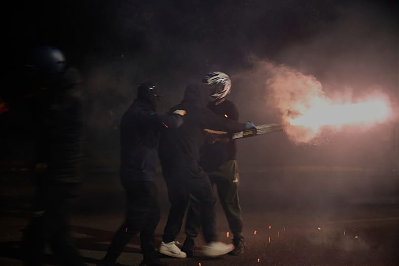 Protesters throw fireworks at riot police during an anti-government protest in Tirana, Albania, Monday, Oct. 19, 2026.