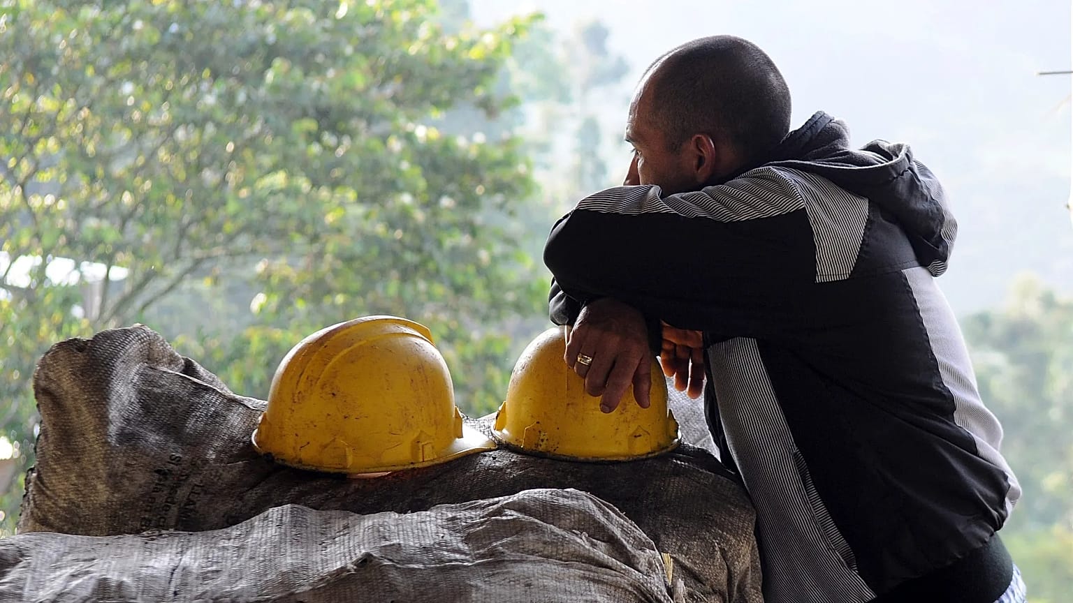 ARCHIVO: Un minero se apoya en su casco, el cual descansa encima de sacos de carbón, en el exterior de la mina de carbón de El Desespero, en Angelópolis, Colombia, en 2012.
