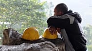 ARCHIVO: Un minero se apoya en su casco, el cual descansa encima de sacos de carbón, en el exterior de la mina de carbón de El Desespero, en Angelópolis, Colombia, en 2012.