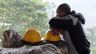 ARCHIVO: Un minero se apoya en su casco, el cual descansa encima de sacos de carbón, en el exterior de la mina de carbón de El Desespero, en Angelópolis, Colombia, en 2012.