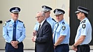 FILE- Australian Prime Minister Anthony Albanese, center, is briefed by police after laying flowers at the Bondi Pavilion, a day after a shooting at Bondi Beach in Sydney