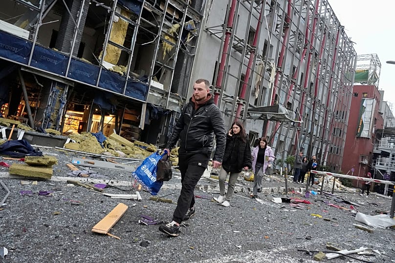 People carry their belongings as they leave their office following a Russian air attack in Kyiv, 19 October, 2026