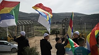 أفراد من الطائفة الدرزية ورجال الدين ينتظرون قرب الحدود الحافلات التي تقل أفراداً من الطائفة الدرزية السورية للعبور من سوريا في قرية مجدل شمس في مرتفعات الجولان