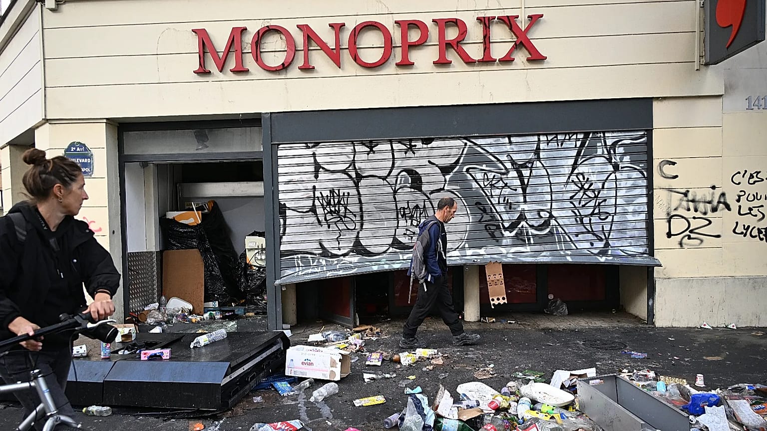 Ένας άνδρας περνά μπροστά από μια λεηλατημένη βιτρίνα την επομένη πορείας κατά της ακρίβειας και υπέρ των φοιτητών, στο Παρίσι, Κυριακή 18 Οκτωβρίου 2026. (AP)