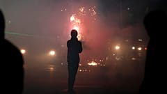 Un manifestante lanza fuegos artificiales contra la policía antidisturbios durante una protesta antigubernamental en Tirana, Albania