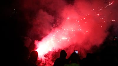 A tüntetők petárdákat és füstbombákat dobálnak a rohamrendőrökre egy kormányellenes tiltakozáson Tiranában, 2026. október 19-én.