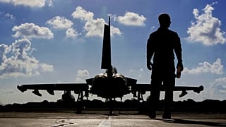 A British soldier walks by a Typhoon aircraft before take off for a mission in Iraq, at RAF Akrotiri, near the southern coastal city of Limassol, Cyprus, Sept. 22, 2016.