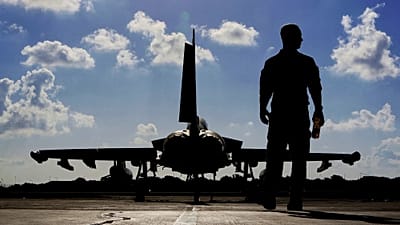 A British soldier walks by a Typhoon aircraft before take off for a mission in Iraq, at RAF Akrotiri, near the southern coastal city of Limassol, Cyprus, Sept. 22, 2016.