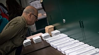ARCHIVO: Un hombre inspecciona las papeletas en un colegio electoral antes de votar en las generales en Barcelona, ​​España, el 28 de abril de 2019.