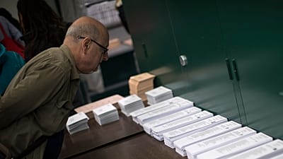 ARCHIVO: Un hombre inspecciona las papeletas en un colegio electoral antes de votar en las generales en Barcelona, ​​España, el 28 de abril de 2019.