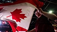 People wave flags at a Forever Canadian rally in Edmonton, on Friday, Oct. 16, 2026. (John Ulan/The Canadian Press via AP)