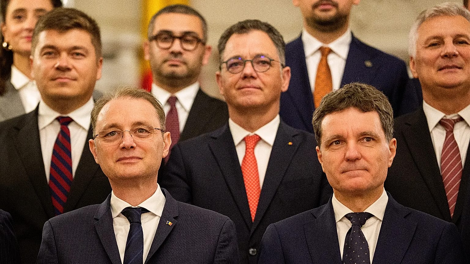 Prime Minister Luca Niculescu, left, smiles standing next to Romanian President Nicusor Dan after a swearing in ceremony for the new government 
