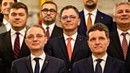 Prime Minister Luca Niculescu, left, smiles standing next to Romanian President Nicusor Dan after a swearing in ceremony for the new government 