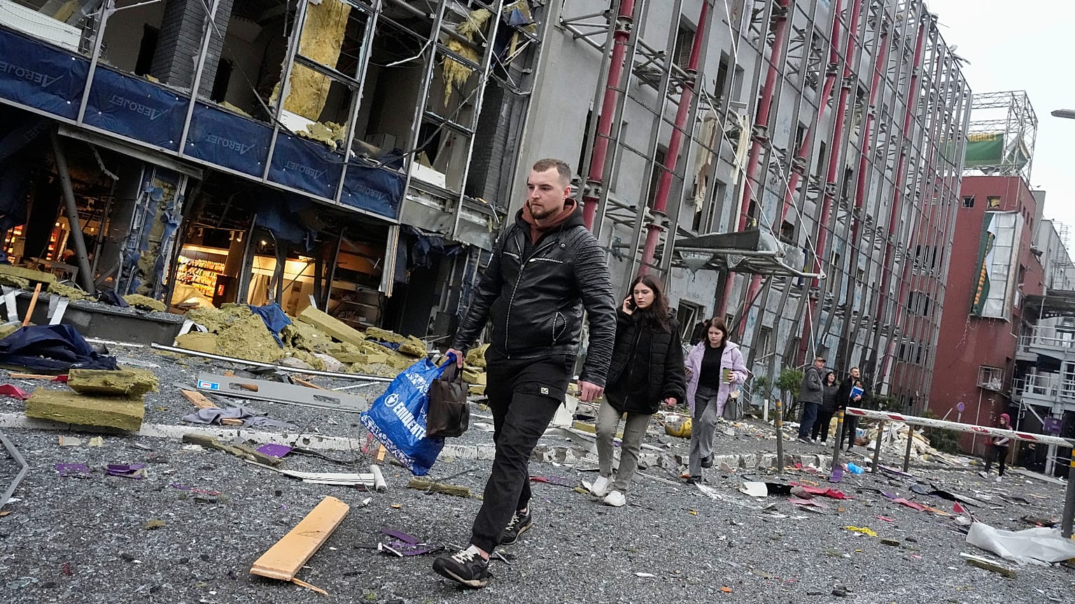  carry their belongings as they leave their office following a Russian air attack in Kyiv