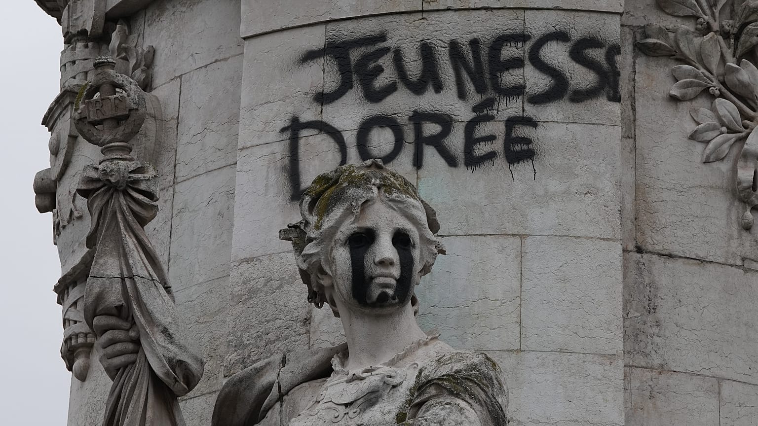 Tagging reading "The golden youth" on the statue of Equality at the Republique square, after a weekend of rioting and looting across France.