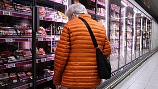 A woman looks through supermarket shelves