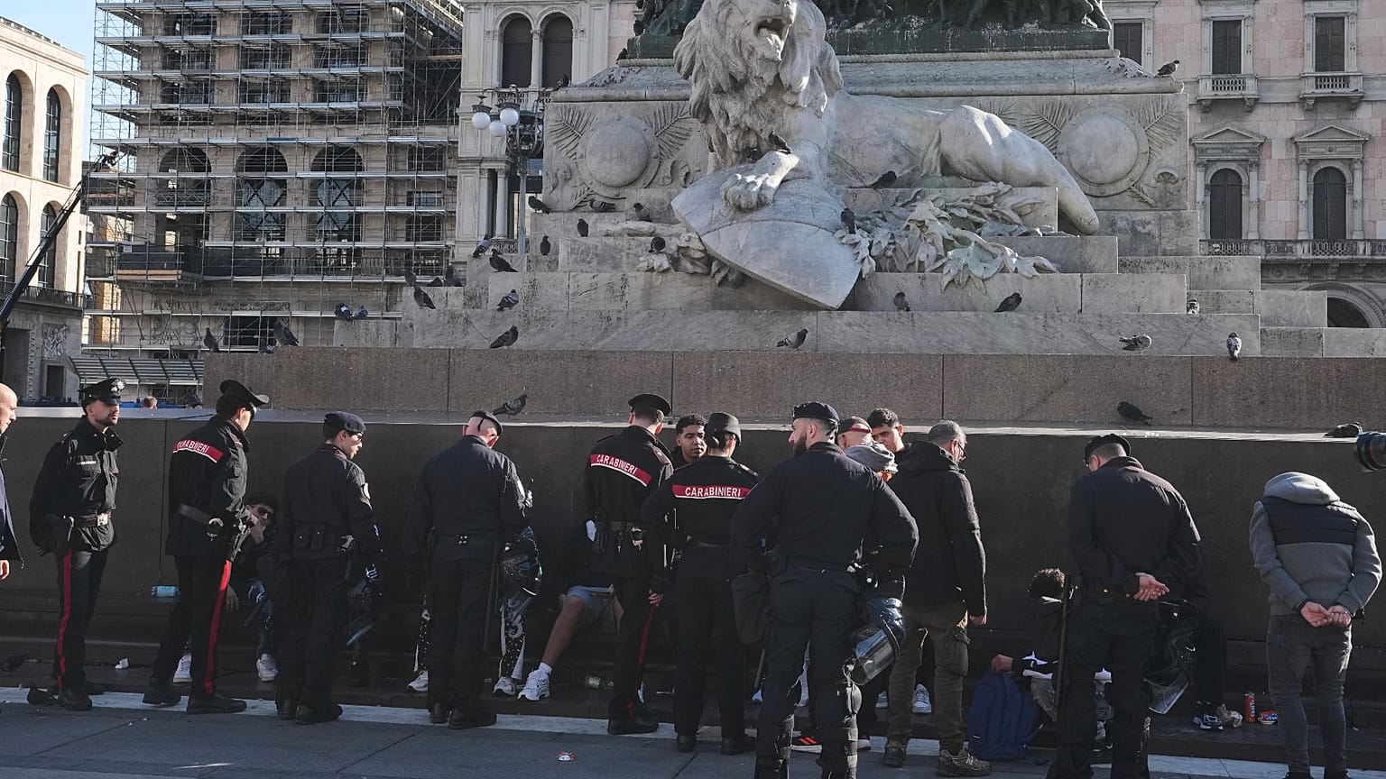 Carabinieri officers talk to people in Duomo square, Milan, Italy, a day after rioters clashed with police, looted stores and set property on fire, Monday, Oct. 16, 2026