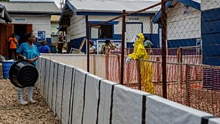 A healthcare worker speaks to a colleague at the Ebola treatment center in Beni, North Kivu province, Congo.