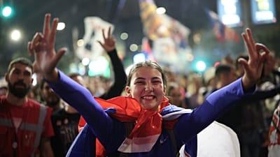 Personas dan la bienvenida a un grupo de estudiantes que llega antes de un mitin preelectoral de 'Lista estudiantil - Los estudiantes ganan' en Belgrado.