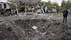 A man looks at a crater after a Russian missile strike in Kyiv