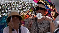 People shelter from the hot sun as Pope Leo's XIV arrives for his weekly general audience in St. Peter's Square at The Vatican, June 24, 2026. 