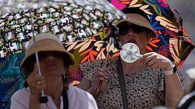 Fiéis procuram abrigo do sol forte enquanto o papa Leão XIV chega para a audiência geral semanal na Praça de São Pedro, no Vaticano, 24 de junho de 2026.