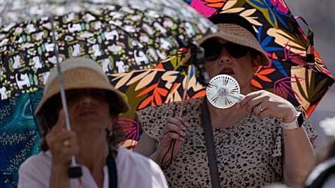 People shelter from the hot sun as Pope Leo's XIV arrives for his weekly general audience in St. Peter's Square at The Vatican, June 24, 2026. 