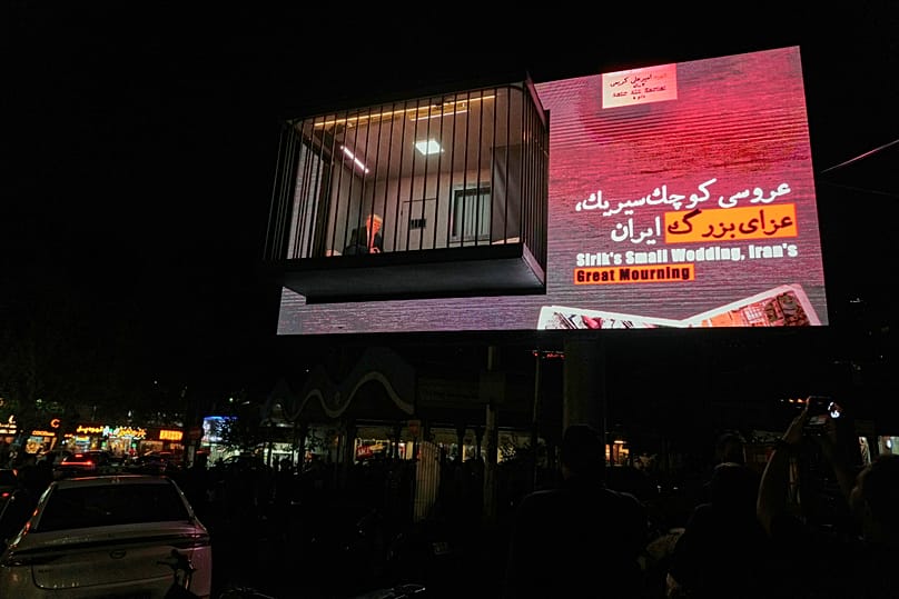 ممثل يؤدي دور الرئيس الأمريكي دونالد ترامب يجلس خلف قضبان داخل مجسم يشبه زنزانة سجن، وذلك في ساحة تجريش بالعاصمة الإيرانية طهران، يوم الأربعاء الموافق 21 أكتوبر 2026. (صورة من