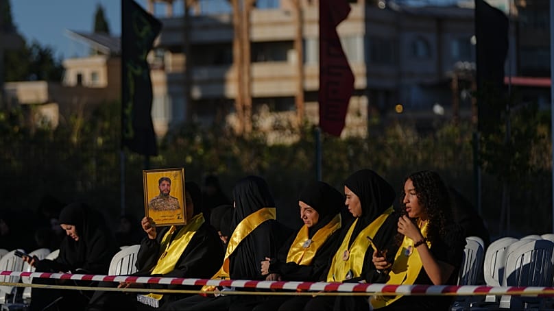 امرأة تحمل صورة لأحد مقاتلي حزب الله، في مدينة صور جنوبي لبنان، الجمعة 19 يونيو 202