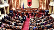 FILE- Lawmakers of the Democratic Party, left, look on as their colleagues of the ruling Socialist party vote in Tirana, Albania, Thursday, Feb. 22, 2024. Albania’s Parliament