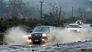 Veículos circulam pela Trabuco Creek Road, em Irvine, Califórnia, atravessando grandes poças de água na manhã de terça-feira, 5 de janeiro de 2016