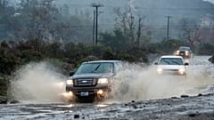 Vehicles make their way along Trabuco Creek Road in Irvine, Calif., through large pockets of water Tuesday morning, Jan. 5, 2016,
