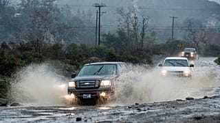 5 Ocak 2016 Salı sabahı Kaliforniya, Irvine'deki Trabuco Creek Road'da araçlar, büyük su birikintilerinin içinden ilerliyor,