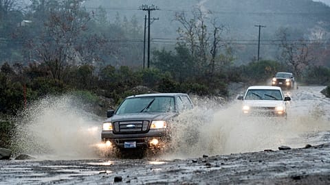 Vehicles make their way along Trabuco Creek Road in Irvine, Calif., through large pockets of water Tuesday morning, Jan. 5, 2016,
