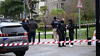 Police stand near a park after a shooting left one person dead and four others wounded in Trappes, outside Paris, Friday, Oct. 23, 2026.