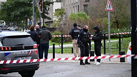Police stand near a park after a shooting left one person dead and four others wounded in Trappes, outside Paris, Friday, Oct. 23, 2026.