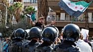 أحد المحتجين يصرخ بينما تقف شرطة مكافحة الشغب للحراسة خلال مظاهرة -أمام مبنى تابع للأمم المتحدة في دمشق بسوريا، يوم الجمعة 23 أكتوبر 2026- احتجاجاً على التوغلات الإسرائيلية دا