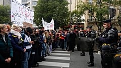 Passersby walk past a boarded-up store on the eve of a demonstration against rising living costs in Paris, Friday, Oct. 23, 2026