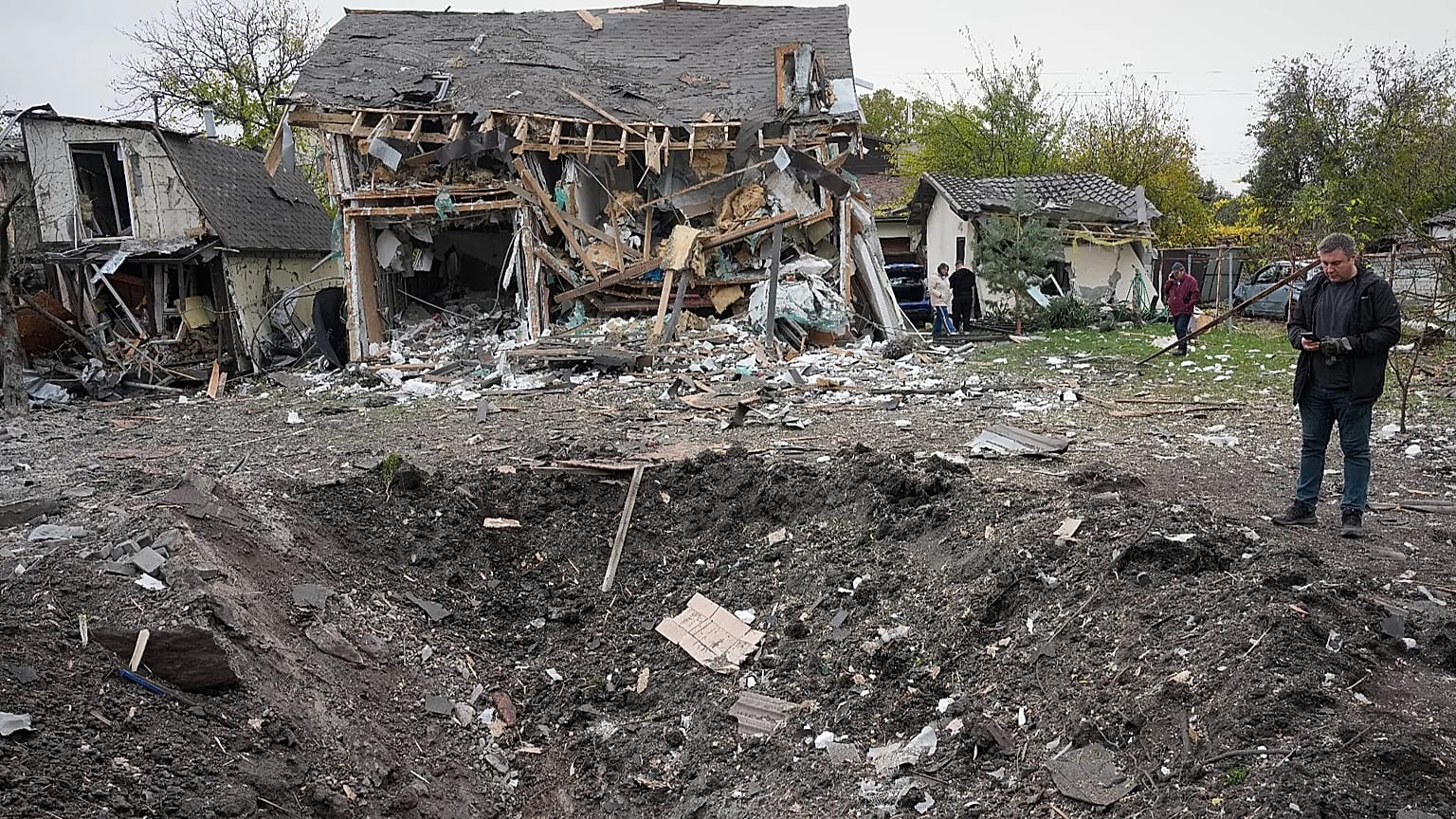 A man looks at a crater after a Russian missile strike in Kyiv, Ukraine, Thursday, Oct. 22, 2026.