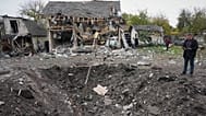 A man looks at a crater after a Russian missile strike in Kyiv, Ukraine, Thursday, Oct. 22, 2026.