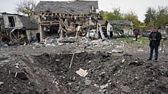 A man looks at a crater after a Russian missile strike in Kyiv, Ukraine, Thursday, Oct. 22, 2026.