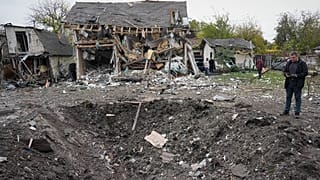 A man looks at a crater after a Russian missile strike in Kyiv, Ukraine, Thursday, Oct. 22, 2026.